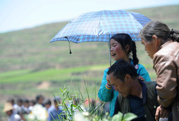 Villagers attend a funeral for their family members in Yongguang village, July 23, 2013.  Villagers say goodbye to quake victims