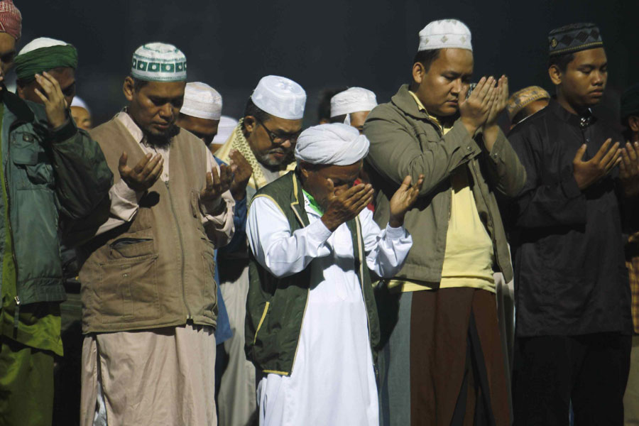 Members of Malaysia's opposition party, Parti Islam Se-Malaysia (PAS), perform a special prayer during a campaign for the upcoming general elections inside a stadium at Kota Bahru, early May 3, 2013.  Special prayer for election in Malaysia