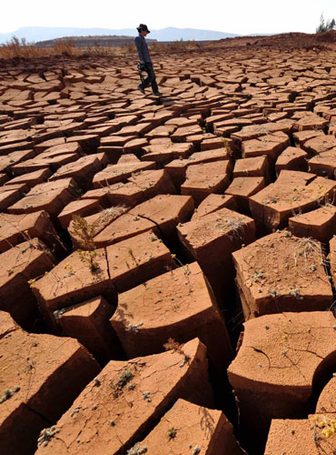 A man walks on a dried pond in Fanglang village in Yunnan, Feb 25, 2012. Millions thirst in Yunnan drought