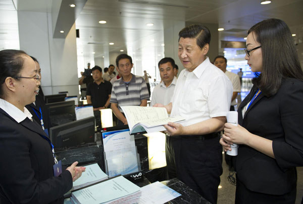 Chinese President Xi Jinping (2nd R), who is also general secretary of the Communist Party of China (CPC) Central Committee, talks with staff members and farmer customers at a rural equity transaction house in Wuhan, capital of Central China's Hubei province, July 22, 2013. Top leader vows to meet growth target