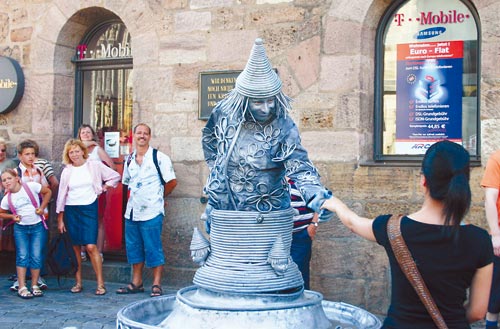 德國(guó)街頭探奇：扮雕塑博美女青睞 胸口碎大石(圖)