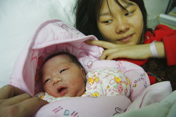Feng Yu smiles at her newborn daughter at Tongji Hospital in Wuhan, capital city of Central China's Hubei province, on Monday. Yang Tao / for China Daily Crew welcomes new life on board