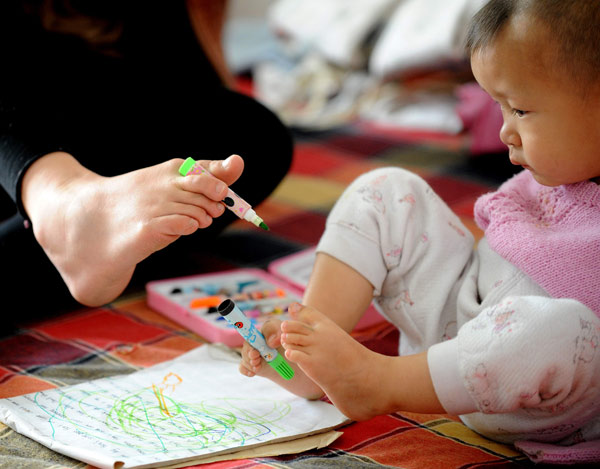 Whenever Luo Fengzhi has time, she visits Wu Zhenfeng, 3, also born armless, and tutors him on how to use his feet. Yan Yan / Xinhua Armless but not defeated