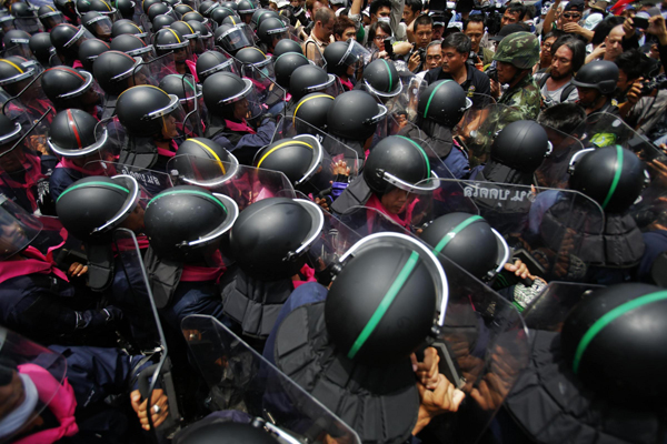 Anti-government protesters confront riot police officers outside the parliament in Bangkok August 7, 2013. Thailand's parliament was due to debate a political amnesty bill on Wednesday as anti-government protesters marched to try to get it scrapped, saying it could let ex-premier Thaksin Shinawatra return from exile without having to serve a jail sentence. Thai lawmakers debate amnesty bill amid protests