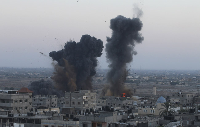 Smoke and flames are seen following what witnesses said were Israeli air strikes in Rafah in the southern Gaza Strip July 9, 2014. 53 dead in Gaza as Israel steps up offensive